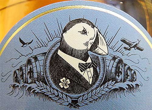 Фирменный герб с атлантическим тупиком в смокинге на этикетке виски Lambay